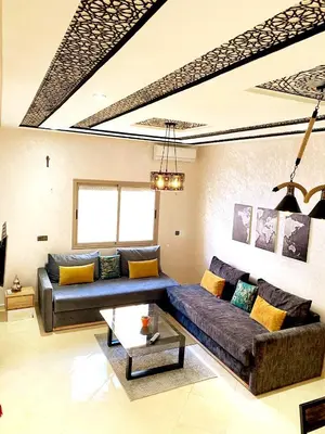 a living room with a couch and a table at (1) Appartement calme in Fès