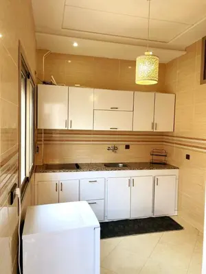 a kitchen with white cabinets and a sink at (1) Appartement calme in Fès