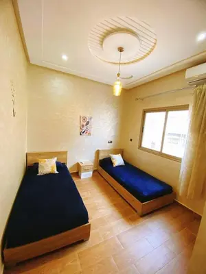 a bedroom with two beds and a window at (1) Appartement calme in Fès