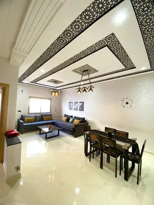 a living room with a couch and a table at (1) Appartement calme in Fès