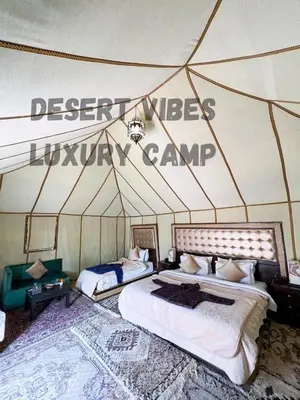a bedroom with two beds in a tent at Desert vibes Luxury camp in Merzouga