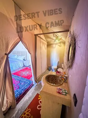 a room with a tent with a stove in it at Desert vibes Luxury camp in Merzouga