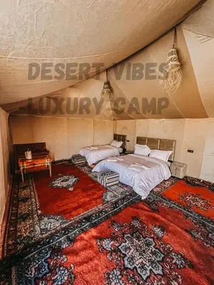 a bedroom with a bed and a large rug at Desert vibes Luxury camp in Merzouga