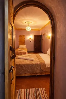 a bedroom with two beds and an open door at DAR DANI café restaurant in Boumalne