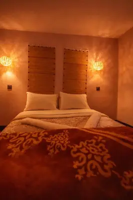 a bedroom with a large bed with two windows at DAR DANI café restaurant in Boumalne