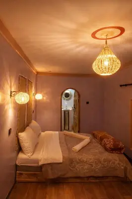 a bedroom with a bed with a mirror and lights at DAR DANI café restaurant in Boumalne