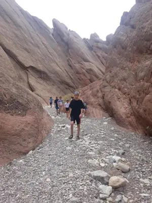 a group of people walking through a canyon at DAR DANI café restaurant in Boumalne