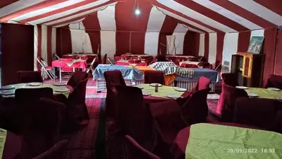 a room with tables and chairs in a tent at Merzougadreamcamp in Merzouga