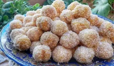 a pile of sugar covered donuts on a blue plate at Merzougadreamcamp in Merzouga