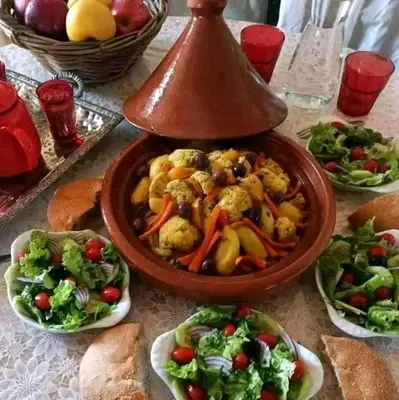 a table topped with plates of food and vegetables at Merzougadreamcamp in Merzouga