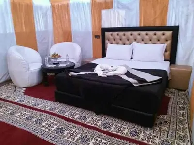 a woman laying on a bed in a bedroom at Merzougadreamcamp in Merzouga
