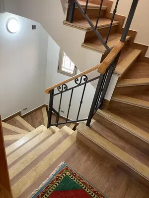 a staircase with wooden treads and a rug at Jaddou Home in Midelt