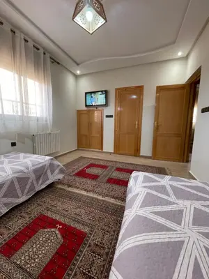 a bedroom with a bed and a tv on the wall at Jaddou Home in Midelt