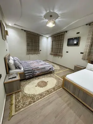 a bedroom with a bed and a couch and a tv at Jaddou Home in Midelt