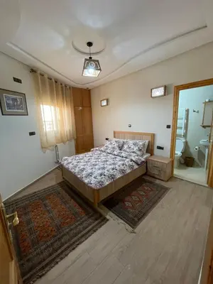 a bedroom with a large bed and a bathroom at Jaddou Home in Midelt