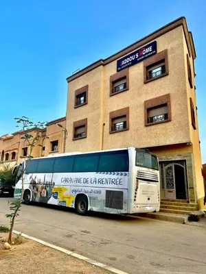 a bus parked in front of a building at Jaddou Home in Midelt