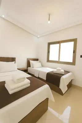 a bedroom with two beds and a window at Serenity apartments in Azrou