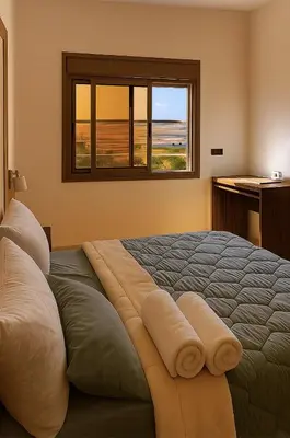 a bedroom with a bed with two pillows and a window at Serenity apartments in Azrou