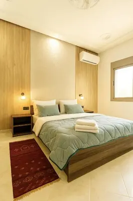 a bedroom with a large bed with two towels on it at Serenity apartments in Azrou