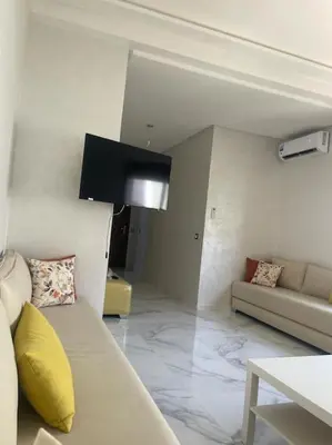 a living room with a couch and a tv at Luxe & Air Conditionner & Calme appartement in Fès