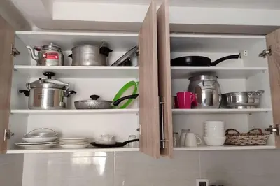 a kitchen cabinet filled with pots and pans at Luxe & Air Conditionner & Calme appartement in Fès