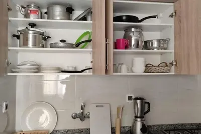 a kitchen cabinet filled with lots of pots and pans at Luxe & Air Conditionner & Calme appartement in Fès