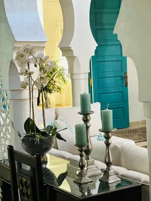 a living room with a couch and a table with candles at Maison Amâra Marrakech in Marrakech