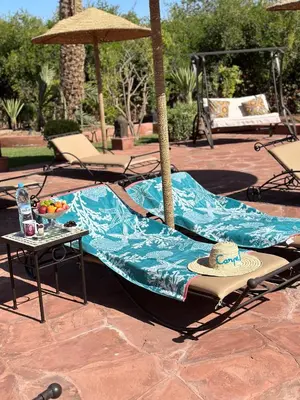 a table with a blanket and a hat on it at Maison Amâra Marrakech in Marrakech