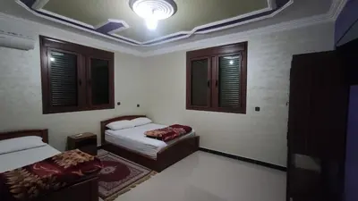 a bedroom with two beds and a ceiling at IAZAL Hotel Ouarzazate in Ouarzazate