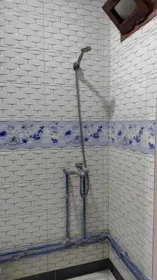 a shower in a bathroom with blue and white tiles at IAZAL Hotel Ouarzazate in Ouarzazate