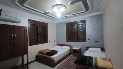 a bedroom with two beds and a ceiling at IAZAL Hotel Ouarzazate in Ouarzazate