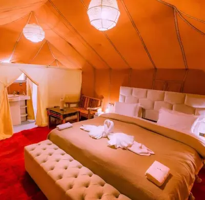 a bedroom with a bed in a tent at Majestic Dunes Luxury Camp in Merzouga