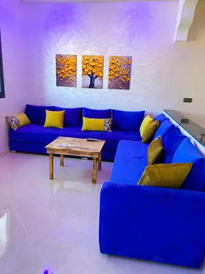 a living room with a blue couch and a table at Appartement Calme (1) in Fès