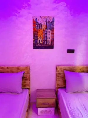 a bedroom with two beds and a painting on the wall at Appartement Calme (1) in Fès