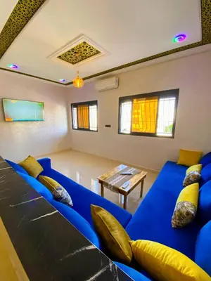 a living room with a blue couch and a table at Appartement Calme (1) in Fès