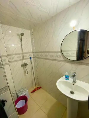 a bathroom with a sink and a shower with a mirror at Appartement Calme (1) in Fès