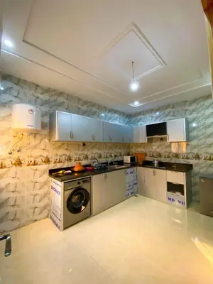 a kitchen with a stove and a washing machine at Appartement Calme (1) in Fès