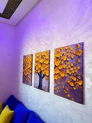 three paintings of a tree on a wall at Appartement Calme (1) in Fès