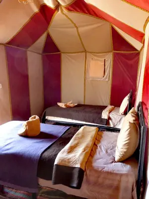 a room with two beds in a tent at Majestic Mirage Camp in Merzouga