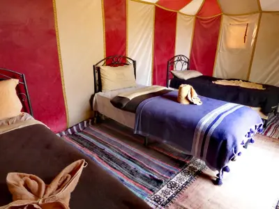 a room with two beds in a tent at Majestic Mirage Camp in Merzouga