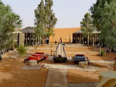 a building with a group of chairs in front of it at Majestic Mirage Camp in Merzouga