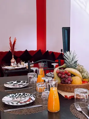 a table with a basket of fruit and orange juice at CHAY - Appartements a Ouarzazate in Ouarzazate