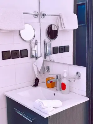 a bathroom with a white sink and a mirror at CHAY - Appartements a Ouarzazate in Ouarzazate