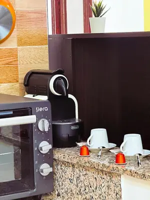 a kitchen counter with a stove with a microwave at CHAY - Appartements a Ouarzazate in Ouarzazate