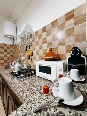 a kitchen with a counter top with a microwave at CHAY - Appartements a Ouarzazate in Ouarzazate