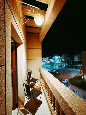 a balcony with two chairs and a table on a building at CHAY - Appartements a Ouarzazate in Ouarzazate