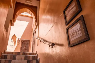 a staircase in a building with two pictures on the wall at Kasbah Tiziri in Kalaat MGouna