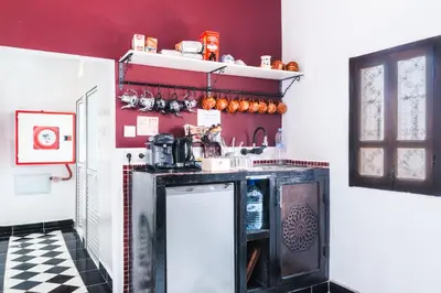 a kitchen with red walls and a black and white checkered floor at Kasbah Tiziri in Kalaat MGouna