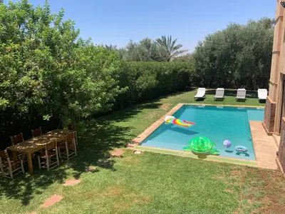 a swimming pool with a person in the water at Sliwa house la Perle de la ville Ocre in Marrakech
