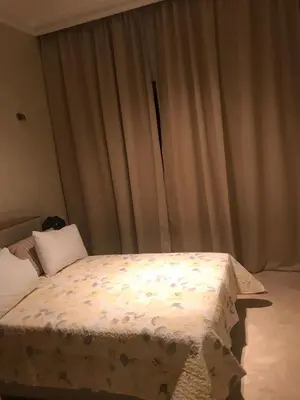 a bed in a bedroom with curtains in the background at Sliwa house la Perle de la ville Ocre in Marrakech